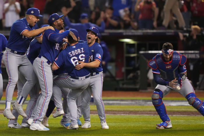 Texas Rangers catcher Jonah Heim, right, retrieves the game ball while celebrating after winning Game 5 of the 2023 World Series against the Arizona Diamondbacks at Chase Field in Phoenix on Nov. 1.